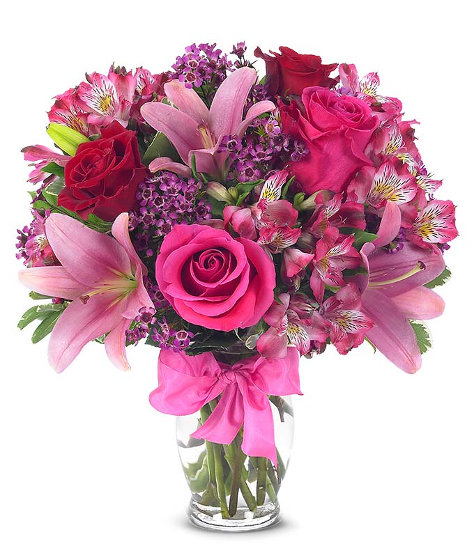 Red roses, pink lilies and pink alstroemeria and glass vase